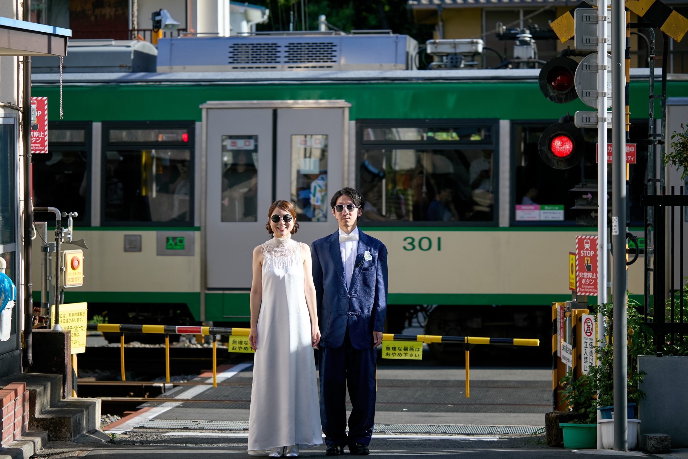 世田谷線の電車を背景に並ぶAtsushiとWakako